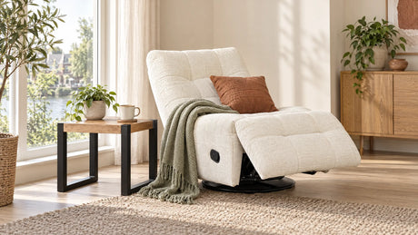 Relaxfauteuil in lichte stof half uitgeklapt bij het raam met een bijzettafel