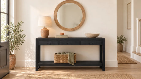 Gestylde sidetable in de hal met lamp, boeken, schaal en een ronde spiegel